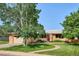 Inviting home featuring mature landscaping, a brick walkway, and a well-manicured lawn at 2300 Crabtree Dr, Centennial, CO 80121