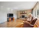 Cozy living room features a stone fireplace, hardwood floors, and natural light from a large window at 2300 Crabtree Dr, Centennial, CO 80121