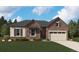 Charming stone and siding home with a two-car garage, well-manicured lawn, and professional landscaping at 9147 Ironwood St, Highlands Ranch, CO 80129