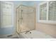 Bathroom with bathtub, shower with glass door, and white window shutters at 9864 Carmel Ct, Lone Tree, CO 80124