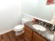 Powder room with granite countertop, wood cabinets and wood floors at 9864 Carmel Ct, Lone Tree, CO 80124