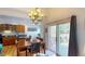 Dining room with chandelier, wooden floors, patio access and an adjacent kitchen area at 9864 Carmel Ct, Lone Tree, CO 80124