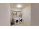 Well-equipped laundry room featuring a full-size washer and dryer and functional shelving for storage and organization at 9864 Carmel Ct, Lone Tree, CO 80124
