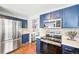 Bright kitchen with stainless steel appliances, ample counter space and a view into the laundry room at 13036 W Cross Dr, Littleton, CO 80127