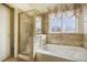 Bathroom with tub and shower, and patterned tiling at 13634 Monroe St, Thornton, CO 80602