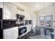Modern kitchen showcases white cabinets, stainless steel appliances, and black tile flooring at 13634 Monroe St, Thornton, CO 80602