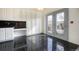 Bright kitchen features white cabinetry, black countertops, and a door to the backyard at 13634 Monroe St, Thornton, CO 80602
