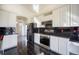 Modern kitchen featuring stainless steel appliances, black countertops, and tiled floors at 13634 Monroe St, Thornton, CO 80602