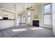 Bright living room with high ceilings, fireplace, large windows, and stylish ceiling fan at 13634 Monroe St, Thornton, CO 80602