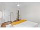 Bright bedroom featuring hardwood floors, white walls, a comfortable bed, and a full-length mirror at 936 Utica St, Denver, CO 80204