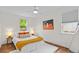 Comfortable bedroom featuring hardwood floors, white walls, cozy bed, and ample natural light at 936 Utica St, Denver, CO 80204