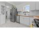 Well-lit kitchen with laundry area, stainless steel appliances, white cabinets, wood countertops, and subway tile backsplash at 936 Utica St, Denver, CO 80204