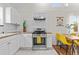 Stylish kitchen with white cabinets, wood countertops, stainless steel range, and adjacent dining area with yellow chairs at 936 Utica St, Denver, CO 80204