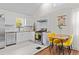 Bright kitchen with white cabinets, stainless steel appliances, and a view into the living space at 936 Utica St, Denver, CO 80204