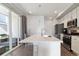 Bright, modern kitchen boasts a center island, stainless appliances, and access to an outdoor patio at 9612 Reunion Pkwy, Commerce City, CO 80022