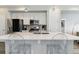 Modern kitchen features white cabinets, stainless steel appliances, and a large center island with seating at 9612 Reunion Pkwy, Commerce City, CO 80022