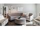 Elegant living room with tufted sofa, ottoman, stylish decor, and plenty of natural light at 9612 Reunion Pkwy, Commerce City, CO 80022