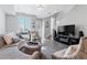 Spacious living room with neutral tones, features plush seating, decor, and large-screen television at 9612 Reunion Pkwy, Commerce City, CO 80022