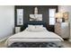 Serene bedroom features a dark accent wall, soft lighting, and a plush, inviting bed at 9612 Reunion Pkwy, Commerce City, CO 80022