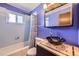 Colorful bathroom with blue walls, retro style blue tile, tub, and a modern vessel sink at 11816 Spring Dr, Northglenn, CO 80233