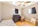 Simple bedroom with hardwood floors, neutral walls, a ceiling fan, and dual windows at 11816 Spring Dr, Northglenn, CO 80233