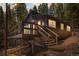 Charming home featuring a wooden porch and situated amongst a dense forest landscape at 153 Sawmill Ln, Idaho Springs, CO 80452