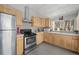 Well-lit kitchen featuring stainless steel appliances, bright wooden cabinets, and tiled backsplash at 153 Sawmill Ln, Idaho Springs, CO 80452