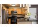 Well-equipped kitchen featuring stainless steel appliances, wood cabinets, and black countertop at 7881 Allison Way # 204, Arvada, CO 80005