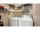 This laundry room features a front loading washer and dryer with shelving for storage at 7881 Allison Way # 204, Arvada, CO 80005
