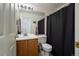 Cozy half bathroom featuring oak vanity, white countertop, and framed mirror with a shower behind a curtain at 22379 E Dorado Ave, Aurora, CO 80015