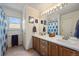 Bright bathroom featuring a double sink vanity with framed mirrors, a window, and coordinating blue accents at 22379 E Dorado Ave, Aurora, CO 80015