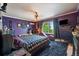 Spacious bedroom with dark walls, stylish decor, a shag rug, and a view of mature trees at 22379 E Dorado Ave, Aurora, CO 80015
