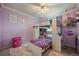 Purple bedroom with a loft bed, rainbow rug, and a desk area with shelves for displaying decorations at 22379 E Dorado Ave, Aurora, CO 80015