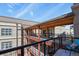 Exterior view of a building showcasing walkways, red brick supports, and metal railing at 5677 S Park Pl # 303, Englewood, CO 80111