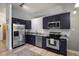 A modern kitchen featuring stainless steel appliances, dark cabinets, and granite countertops, ideal for cooking at 5677 S Park Pl # 303, Englewood, CO 80111
