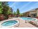 Community pool and hot tub, surrounded by lounge chairs and well-manicured landscaping at 5677 S Park Pl # 303, Englewood, CO 80111