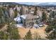 A rear aerial view of a home showing a relaxing backyard with a deck and hot tub at 31699 Southern Hills Pl, Evergreen, CO 80439