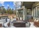 Relaxing back deck featuring cozy seating around a fire pit, perfect for enjoying outdoor living and entertaining guests at 31699 Southern Hills Pl, Evergreen, CO 80439