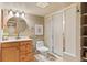 Well-lit bathroom featuring a wood vanity, round mirror, and a glass enclosed shower, providing a functional and stylish space at 31699 Southern Hills Pl, Evergreen, CO 80439