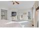 Bright, airy bedroom with ensuite bathroom access, a ceiling fan, a television, and light-colored carpet at 31699 Southern Hills Pl, Evergreen, CO 80439