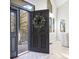 Inviting entryway showcases a black front door with wreath, opening to a bright interior with white floors at 31699 Southern Hills Pl, Evergreen, CO 80439