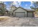 Exterior shot of a home with a three-car garage and covered front porch at 31699 Southern Hills Pl, Evergreen, CO 80439