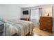 Bedroom with wood floors, a dresser, and patterned bedding at 1400 Bacchus Dr # C11, Lafayette, CO 80026