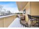 Covered patio with table and chairs, offering views of the snowy neighborhood at 1400 Bacchus Dr # C11, Lafayette, CO 80026