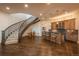 A fully finished basement area with a staircase, wood floors, and a wet bar with cabinet storage at 10805 Evergold Way, Highlands Ranch, CO 80126