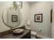 Stylish powder room features a unique glass bowl sink, a decorative mirror, and elegant fixtures at 10805 Evergold Way, Highlands Ranch, CO 80126