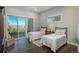 This bedroom is fully furnished, featuring a private balcony, wood floors, and neutral paint at 10805 Evergold Way, Highlands Ranch, CO 80126