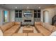 A fully furnished living room with a stone fireplace, built-in cabinets, recessed lighting, and neutral paint at 10805 Evergold Way, Highlands Ranch, CO 80126