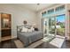 This main bedroom has a sliding glass door, dark hardwood floors, and a view of the well-manicured yard at 10805 Evergold Way, Highlands Ranch, CO 80126