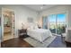 Bright main bedroom with a large bed, dark-wood floors, and access to an outdoor patio at 10805 Evergold Way, Highlands Ranch, CO 80126